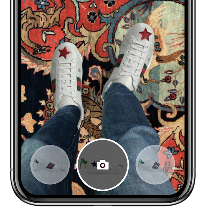 iPhone with Gucci AR app active and showing new virtual shoes on real legs.