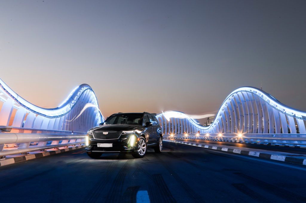 2020 Cadillac XT6 Sport on a bridge at dusk in Dubai.