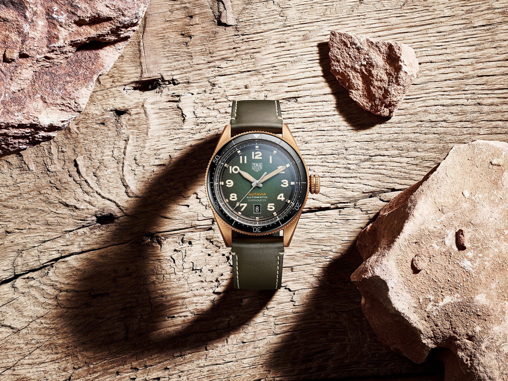 Tag Heuer Autavia in bronze on wooden background with leather strap attached.