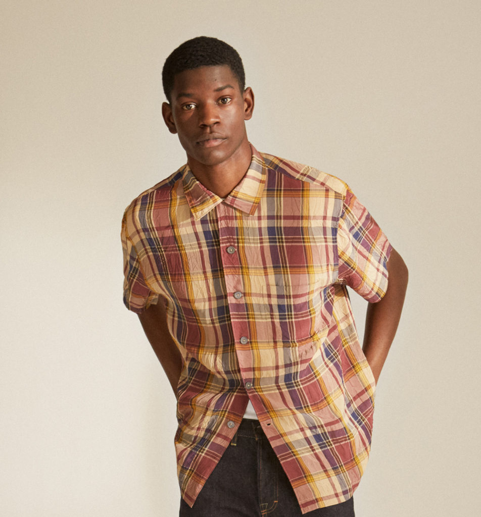Male model wearing Mr P. chequered shirt with his hands in back pocket.