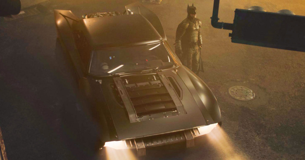 Robert Pattinson as Batman stood next to the new Batmobile.