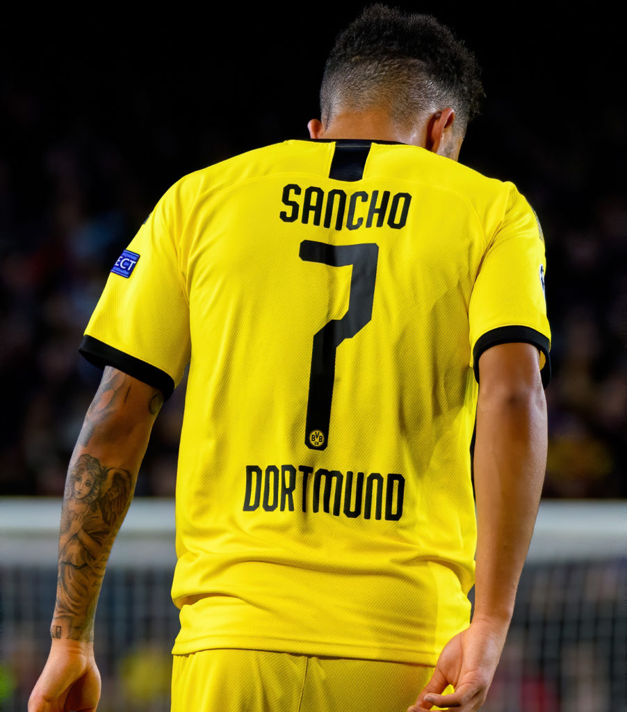 Jadon Sancho facing away from the camera revealing his name and number on the back of his Borussia Dortmund kit.
